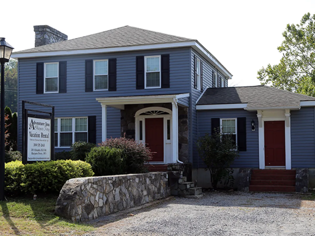 a house with trees in front of a brick building