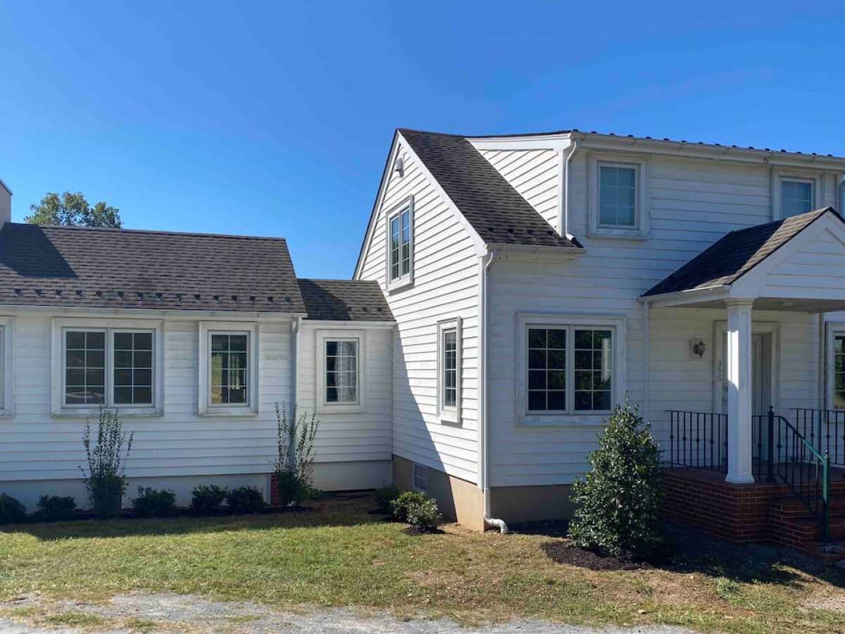 a large lawn in front of a house with Robert Frost Farm in the background