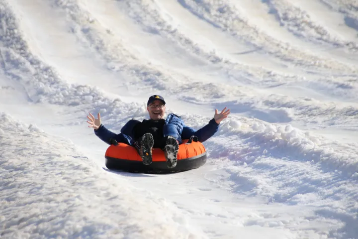 a man riding a snowboard down a snow covered slope