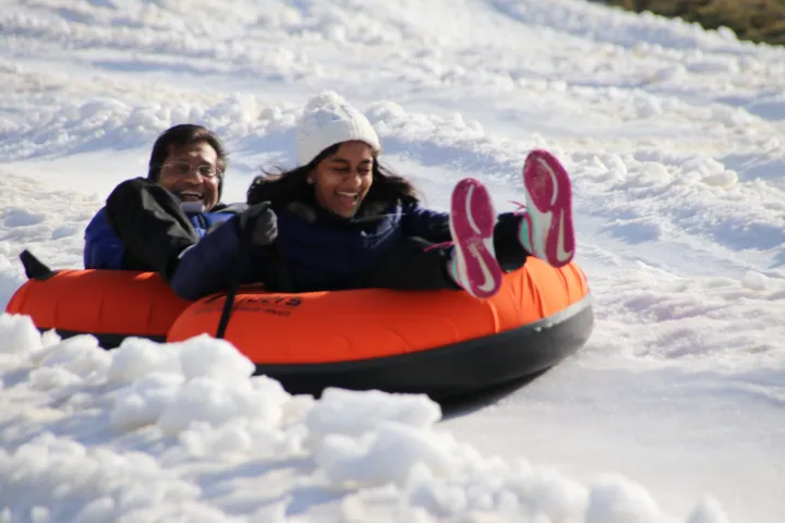 a girl riding a wave on a surfboard in the snow